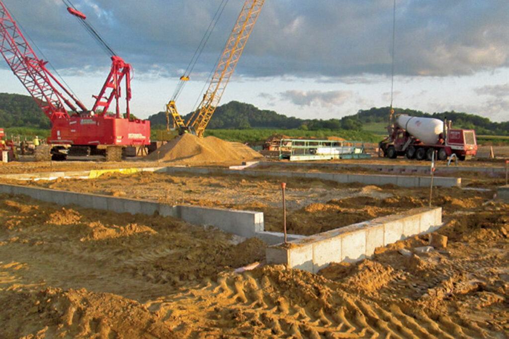 construction site with trucks and cranes