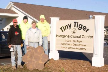 Staab employees standing by a Tiny Tiger sign